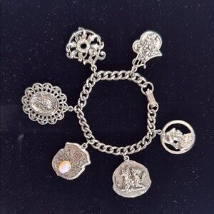 Unique silver toned charm bracelet, charms are mythological, heraldic, religious